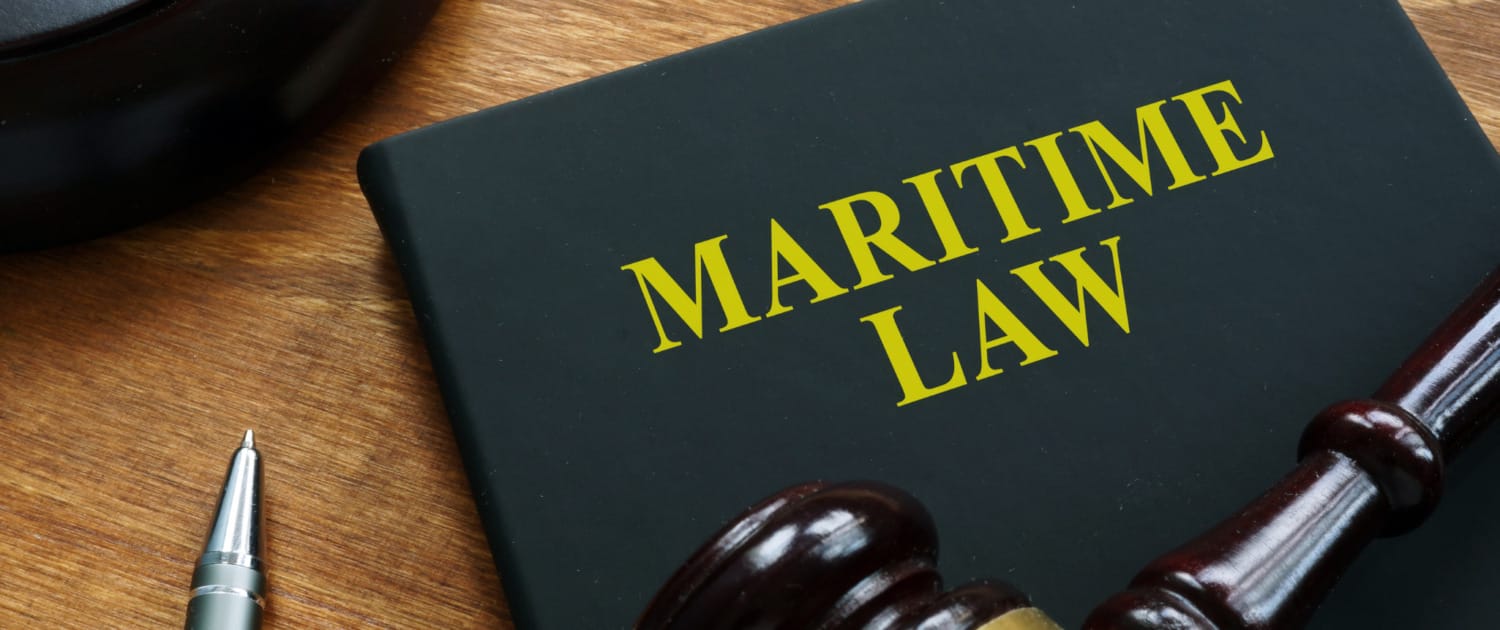 A close-up of a book titled 'Maritime Law' alongside a gavel and pen, symbolizing the impact of legal regulations on the shipping industry, including the Supreme Court's Loper Bright decision and its effects on global supply chains and maritime law.