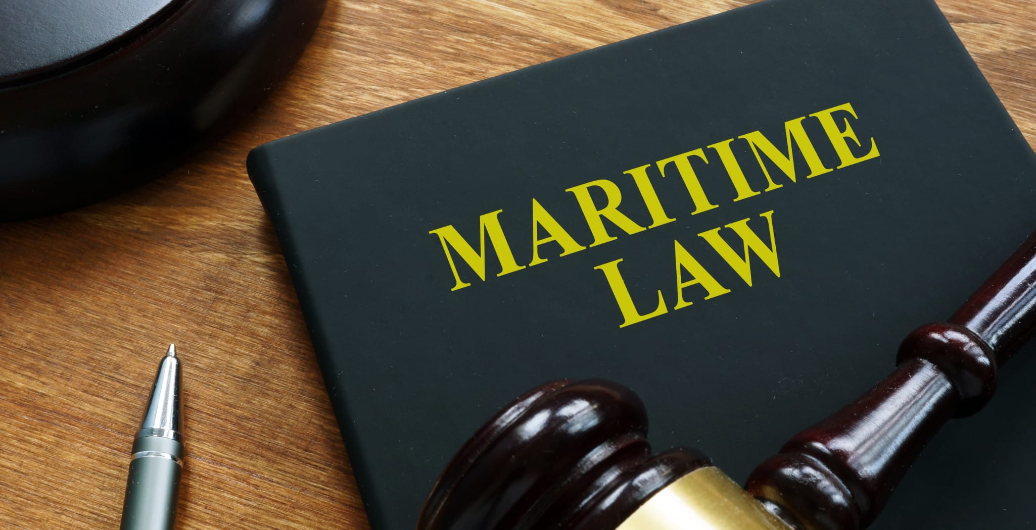 A close-up of a book titled 'Maritime Law' alongside a gavel and pen, symbolizing the impact of legal regulations on the shipping industry, including the Supreme Court's Loper Bright decision and its effects on global supply chains and maritime law.