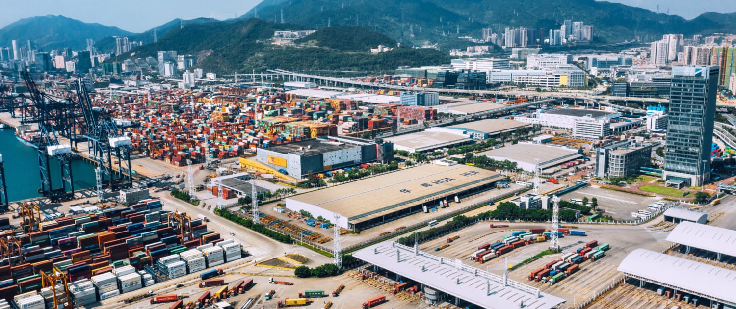 Aerial view of integrated global manufacturing hub showing container port, logistics facilities, and supply chain infrastructure demonstrating the concentrated networks that accelerate production cycles in offshore manufacturing