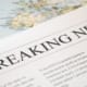 Newspaper headline reading 'Breaking News' placed over a world map, symbolizing global manufacturing supply chain shifts and the impact of international trade policy on sourcing decisions.